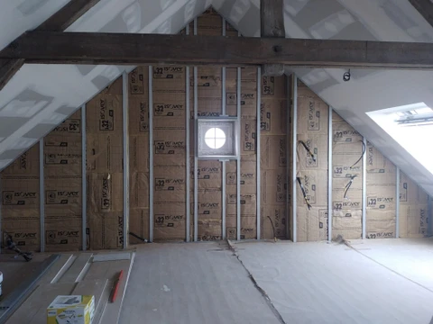 Chantier de construction dans combles aménagés avec charpente bois apparente