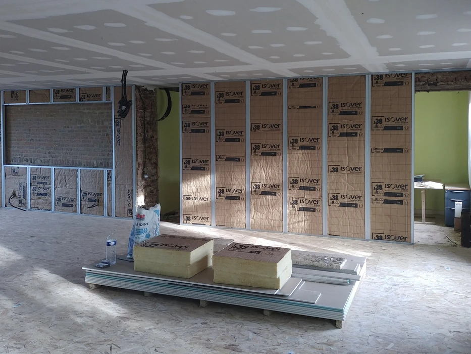 Chantier de rénovation intérieur en cours avec ossature métallique et isolation
