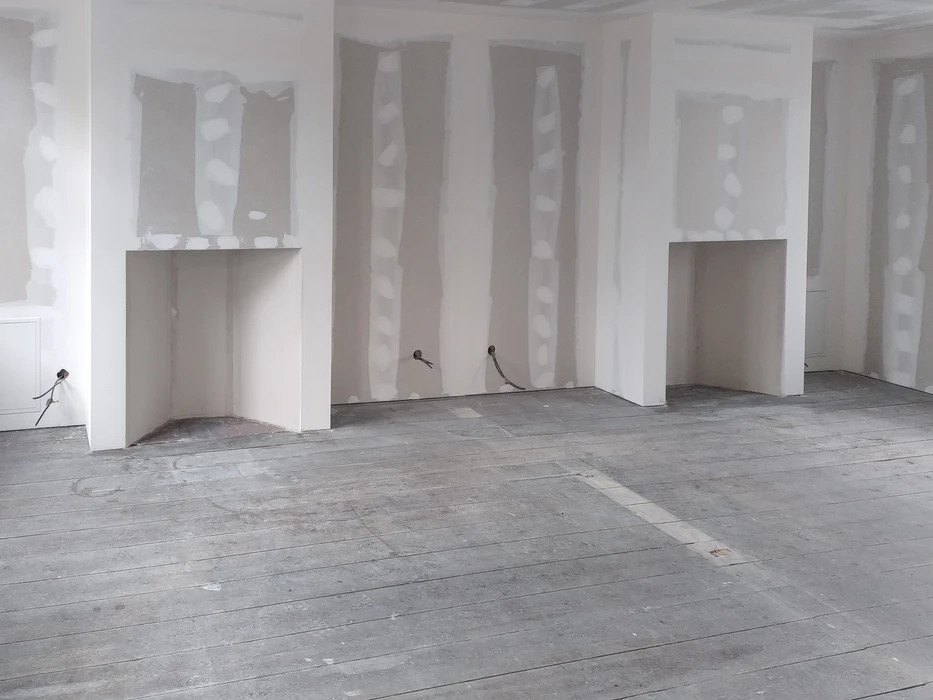 Chantier de construction intérieur en cours d'aménagement avec ouvriers travaillant sur l'installation